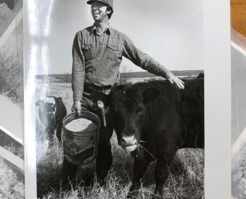 photo of farmer Dwight Coleman smiling next to cattle