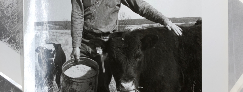 photo of farmer Dwight Coleman smiling next to cattle