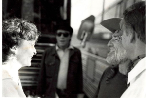 Sarah and Willie Nelson smiling outside tour bus